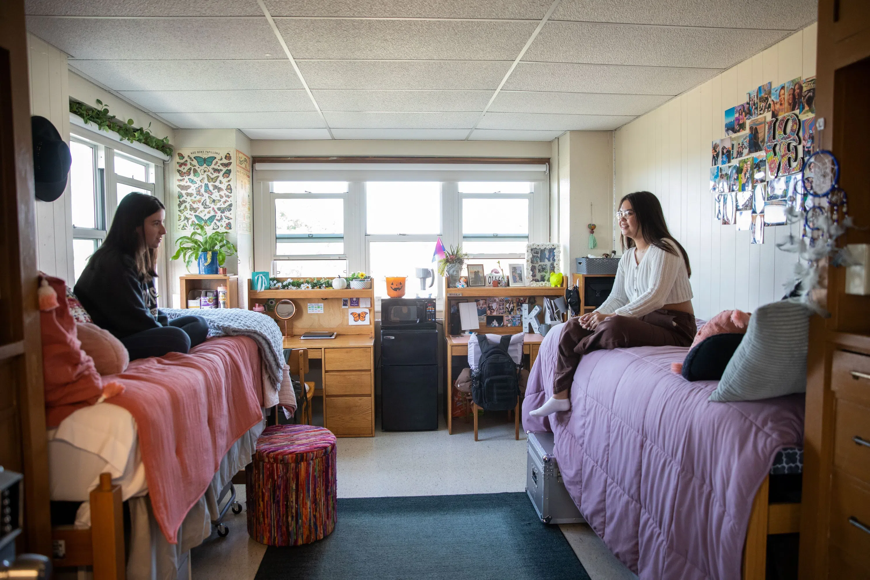 The inside of a dorm room is pictured with students present.