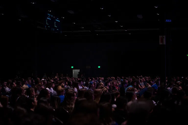 Large group of students sitting watching something on stage