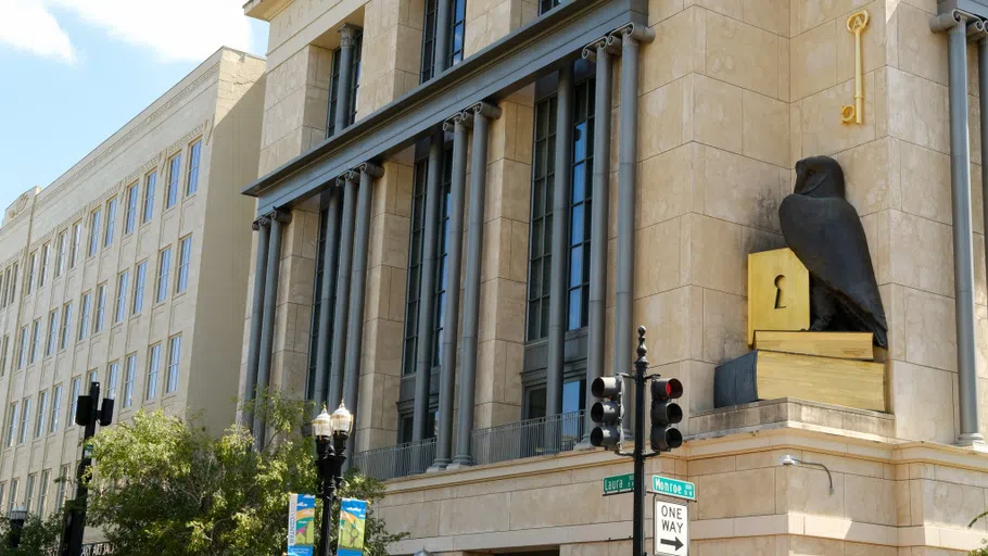 A concrete building with a large statue of a bird on the front corner.