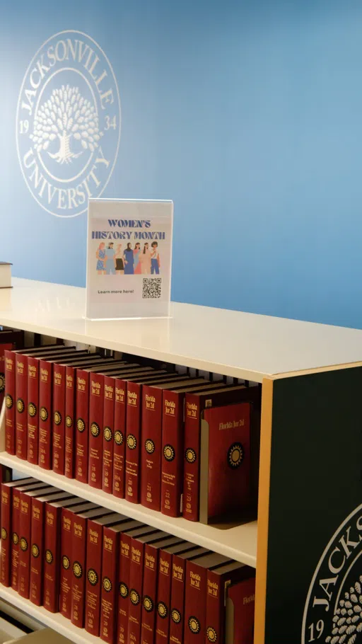 A bookshelf filled with red hardback books.