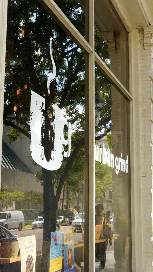 A tinted window with a "U" on it, the logo of Urban Grind Coffee Co.