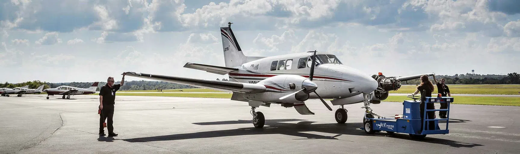 Students assess an airplane parked on the runway.