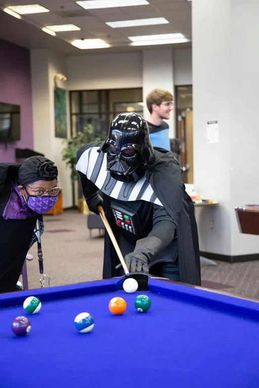 Two students play pool.