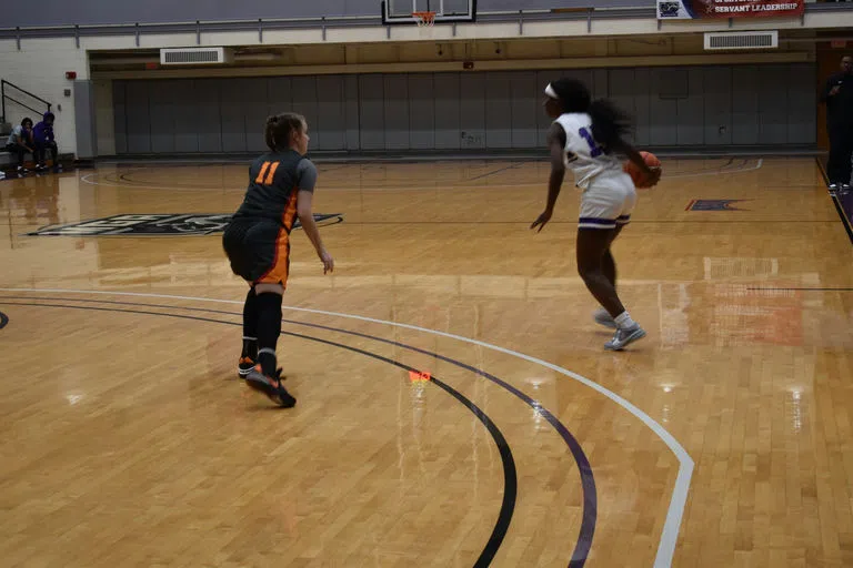 Two student-athletes play basketball.