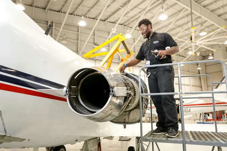 A student inspects an airplane engine.