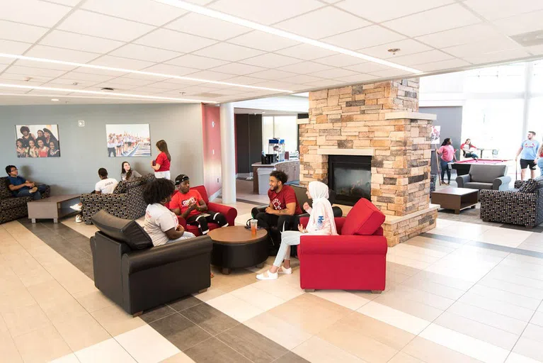 Students spend time in the "lodge," the main lobby in Saints Hall, playing pool, sitting by the fireplace, and chatting on the couches.