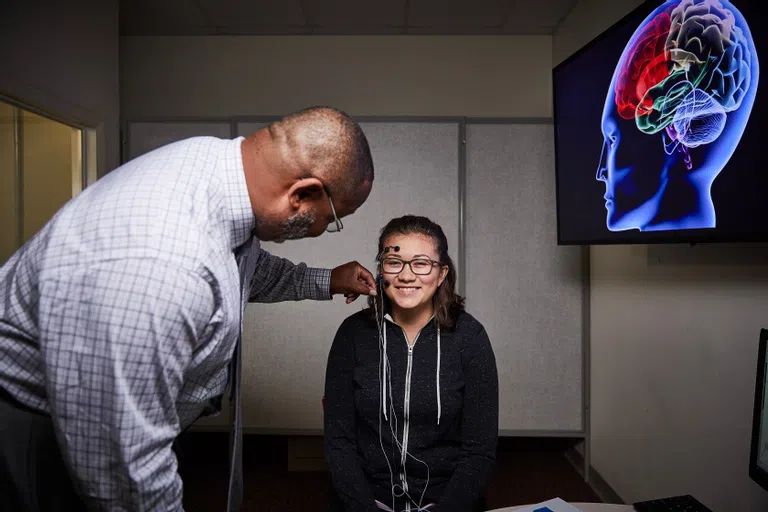 Psychology faculty teach a student how to use the equipment to help them carry out their research for senior seminar. 