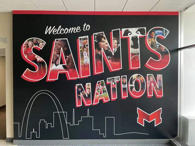 "Welcome to Saints Nation" written on the wall. Each letter has photos of campus life in them.