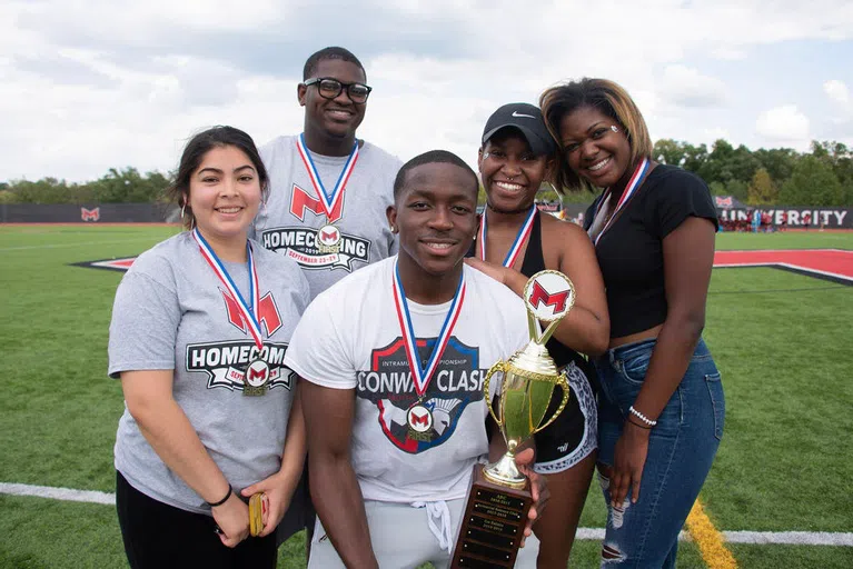 Students on the soccer field after winning a homecoming competition.