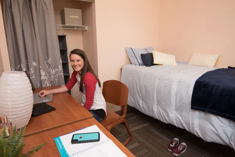 A look into the Apartment bedrooms and bathrooms. Each room has a closet, bed, desk, chair, and set of drawers.