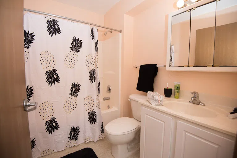 Each bathroom has a shower/tub, toilet, and sink area.