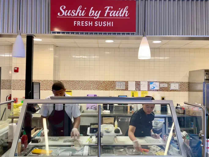 Sushi chefs roll fresh sushi rolls in the dining hall.