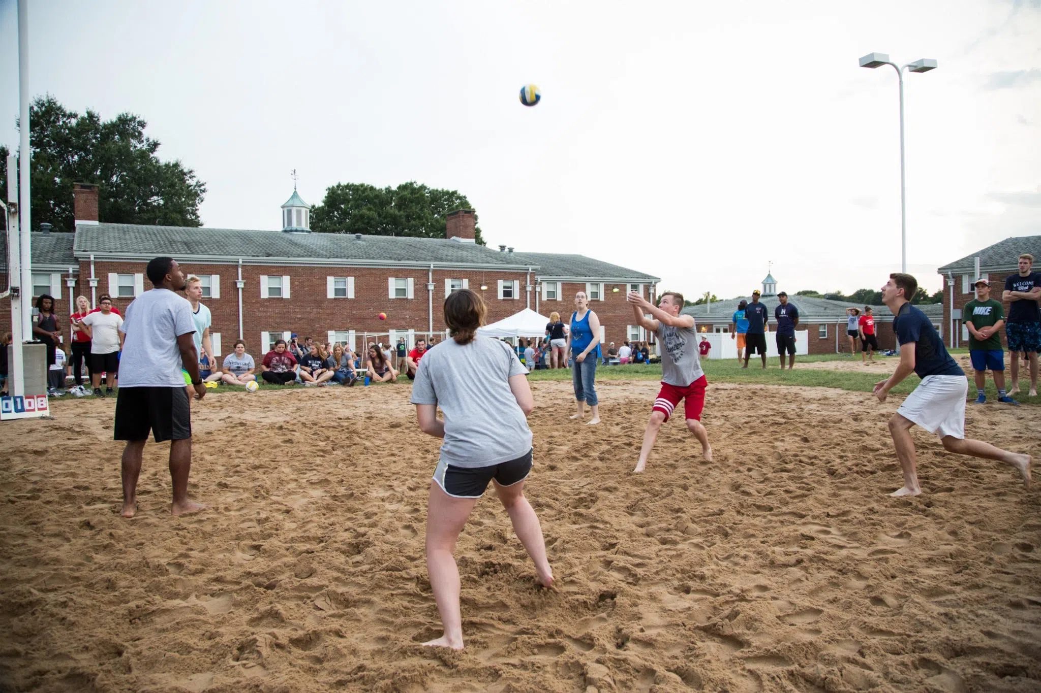 Students play volleyball on the Sand Volleyball Courts
