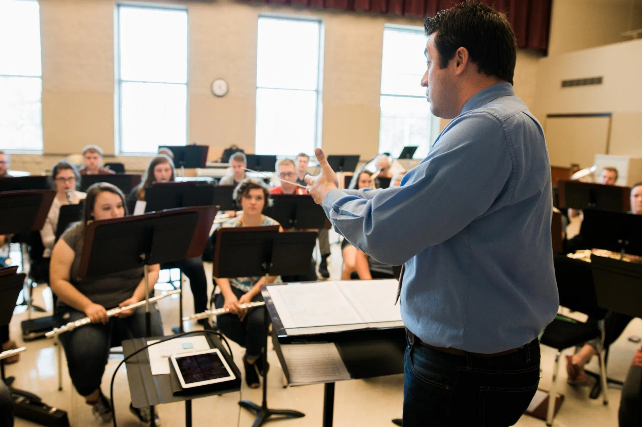 Conductor instructs the band while the students listen. 