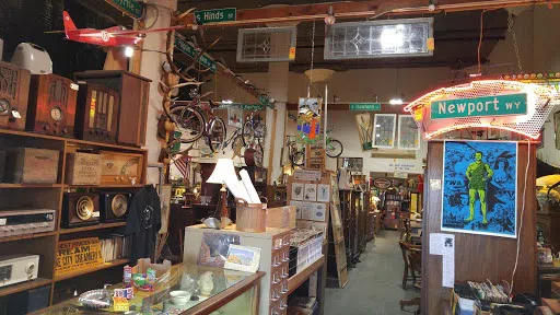 Display of old items including bicycles, lamps, and posters 