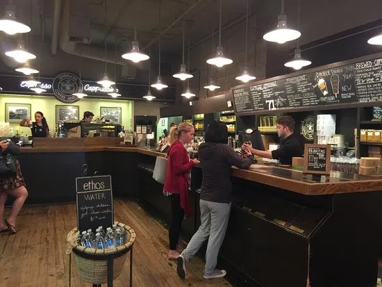 View of the inside of the shop with coffee for sale and signs of menus 