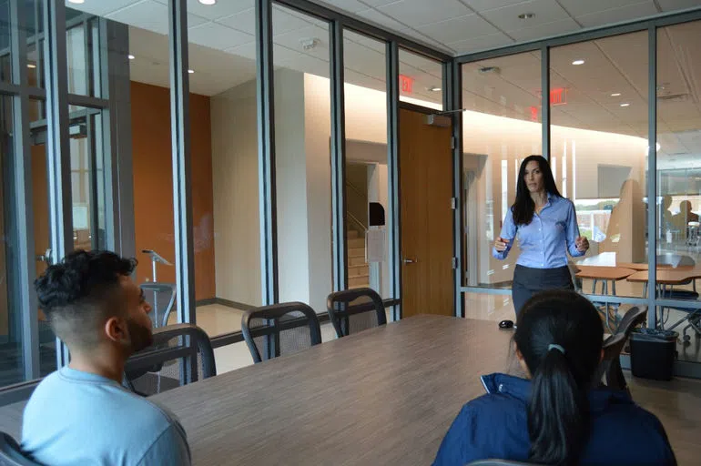 Professor meets with students inside of the Conference Room