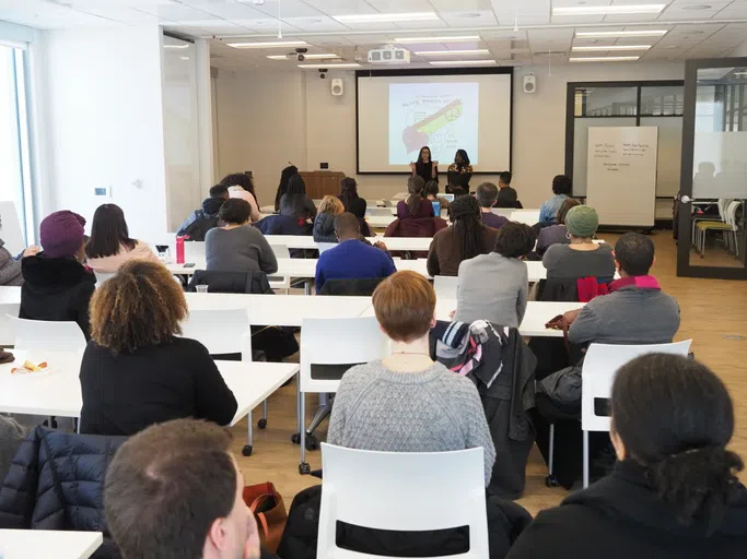 A classroom full of students facing a powerpoint