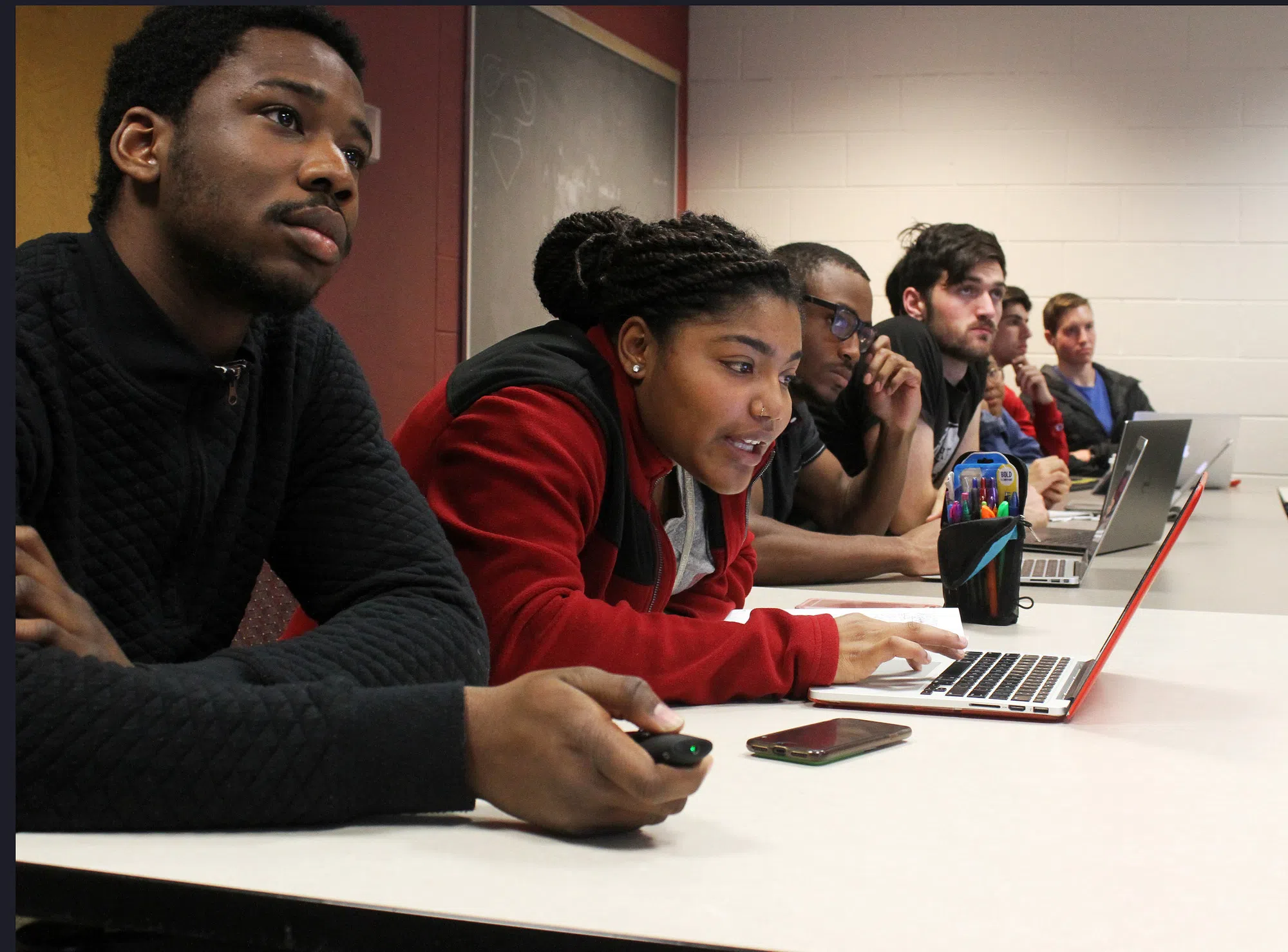 A row of students sit and talk.