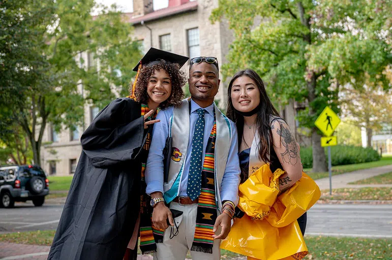 Three students gather for a picture on their graduation day.