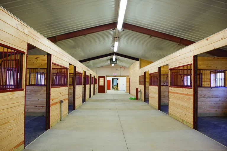 A line of horse stables in a barn.