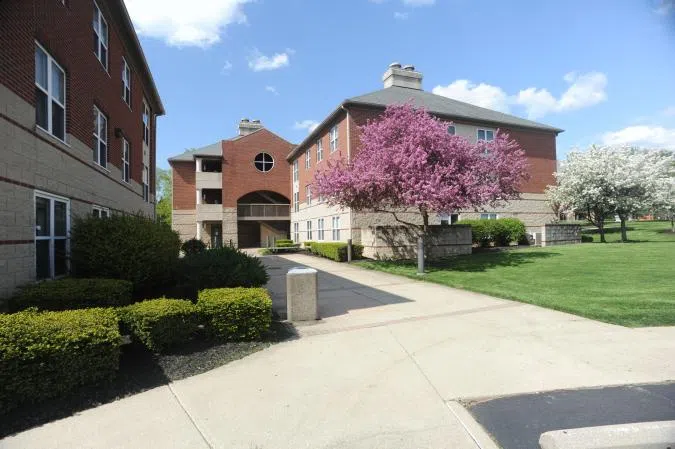 Main view of The Commons on Park. A cluster of brick and concrete apartment buildings surrounded by green areas.