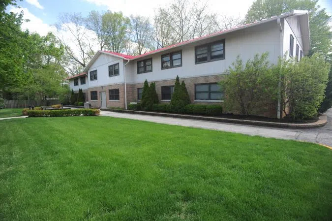 View of the Engle Hall facade, a long two-story building with a large green area.