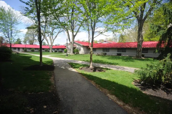 View of the green area among the three buildings of The Triad, with picnic tables and shade trees.