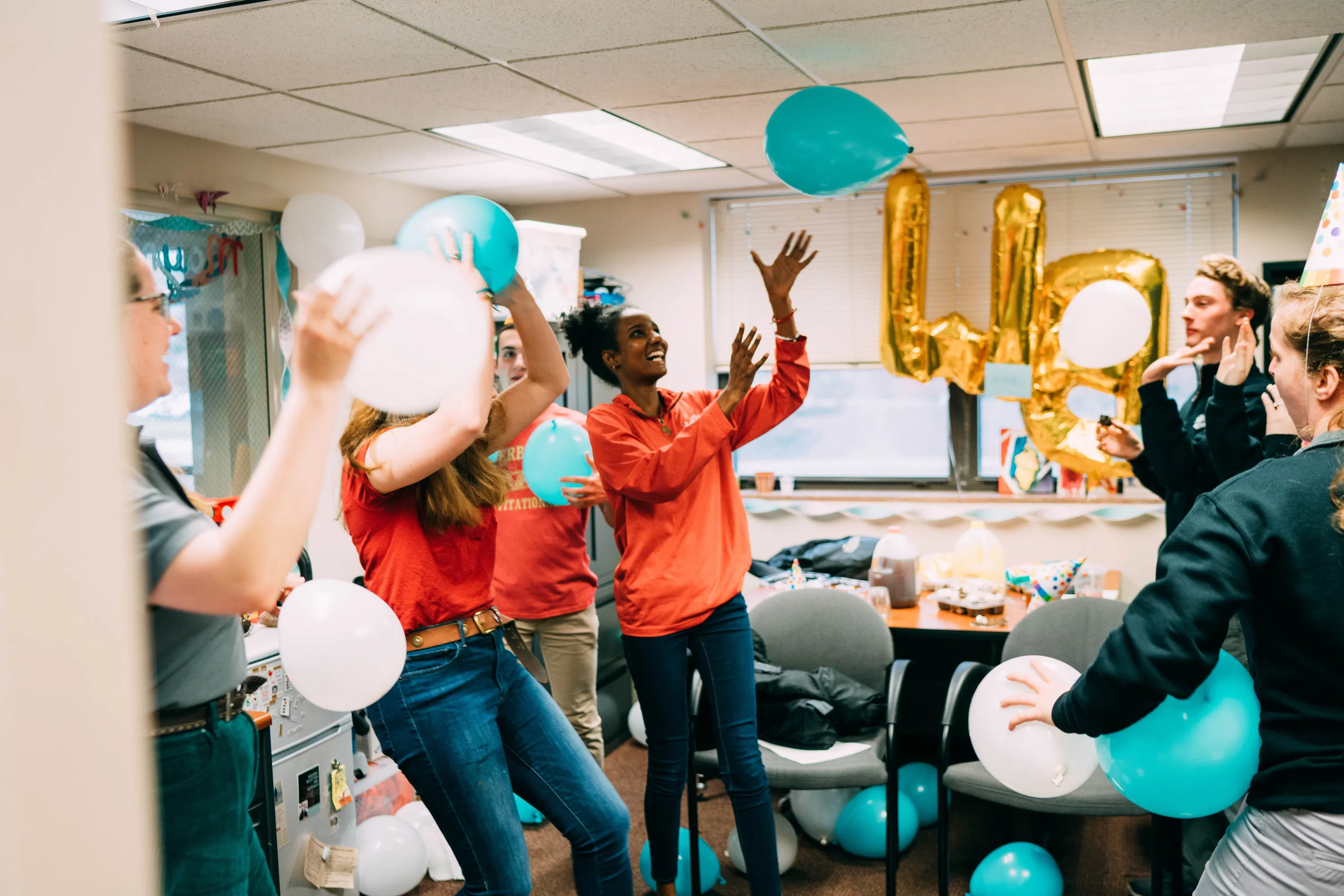 RAs and students have fun with balloons and eat cake at a Res Life party.