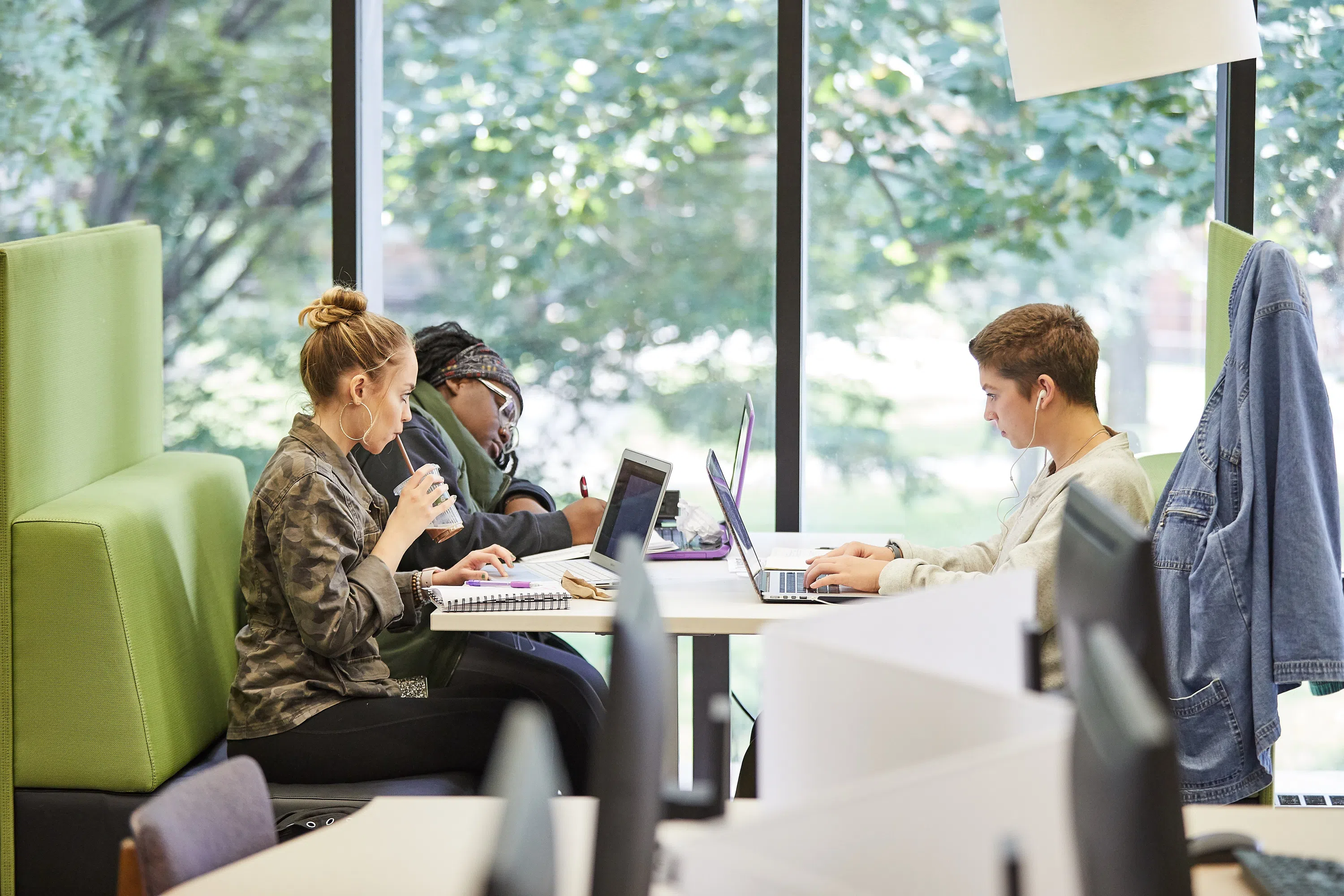 A diverse group of students study together at a table in the Library.