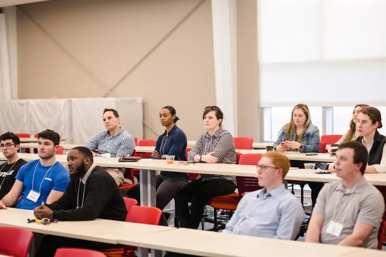 A group of people in the crowd of a classroom.