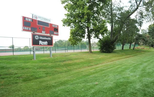 A soccer field with a scoreboard.