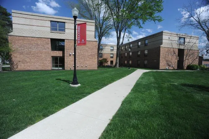 View of the grounds around 25 West Home. A concrete path is surrounded by green areas.