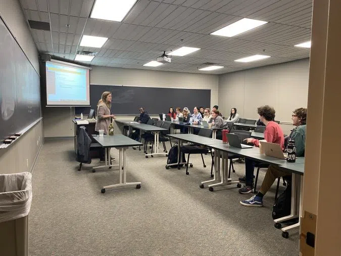 A classroom of students listening to their professor.