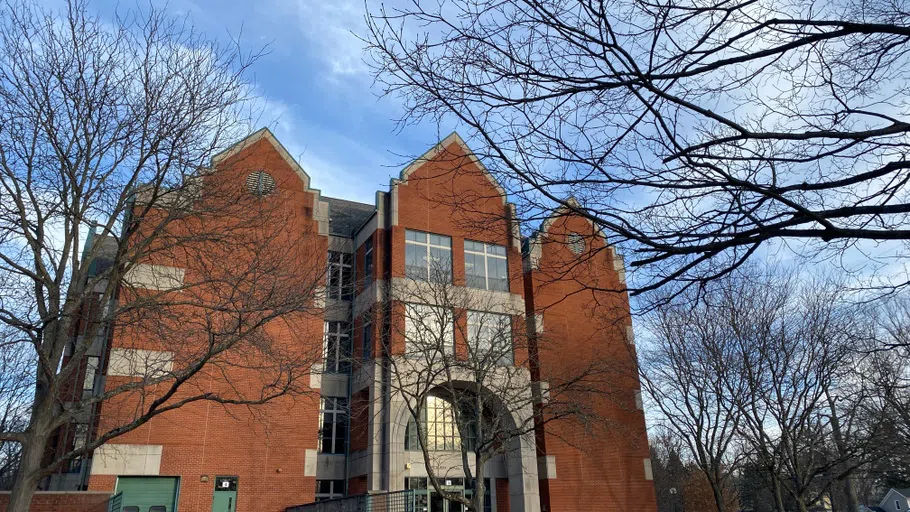 Red brick building against a blue sky with wispy clouds. 