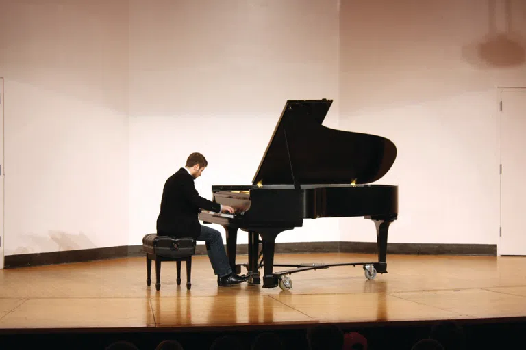 A man in a suit plays the piano