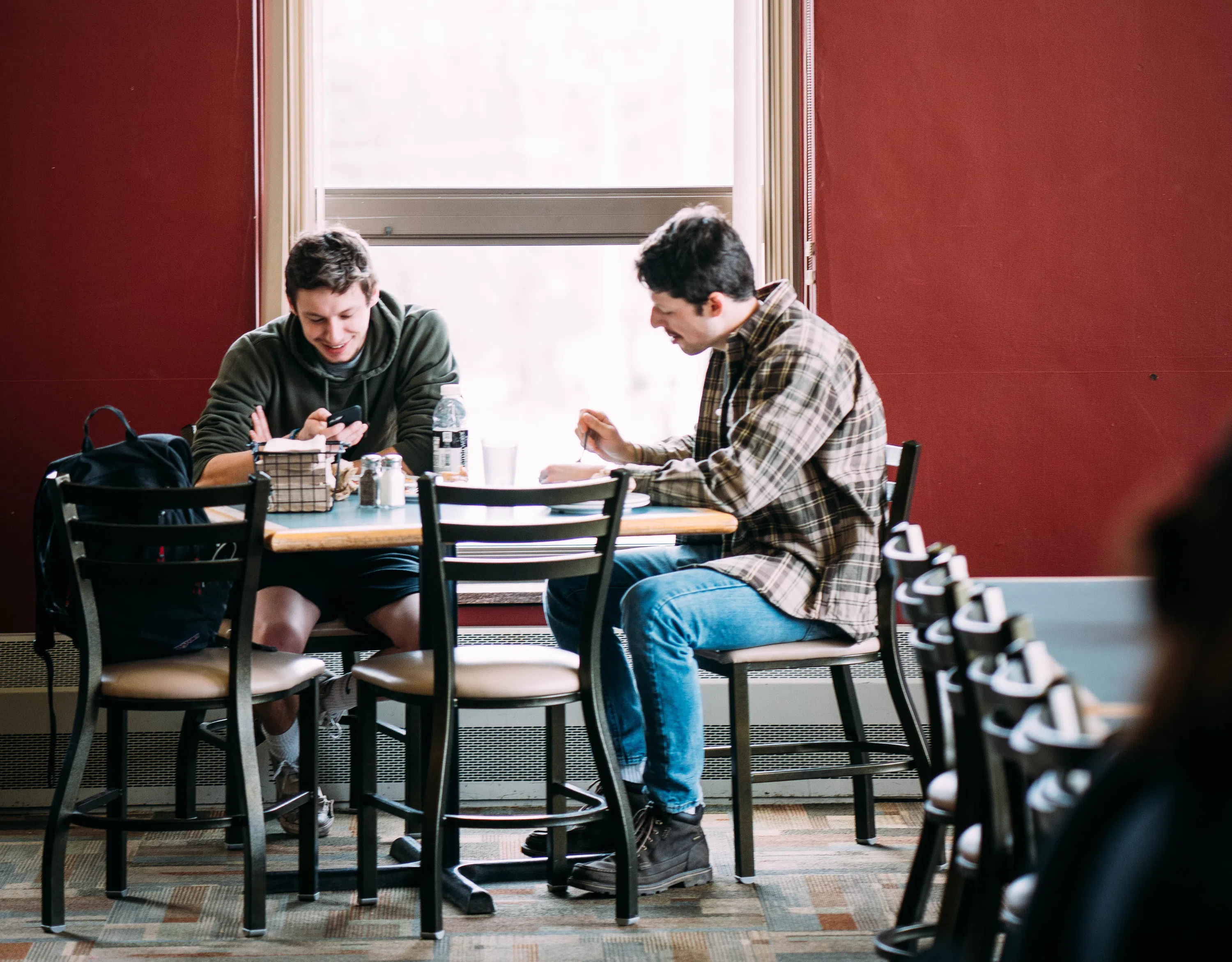 Two students sit together at a table in the Campus Center