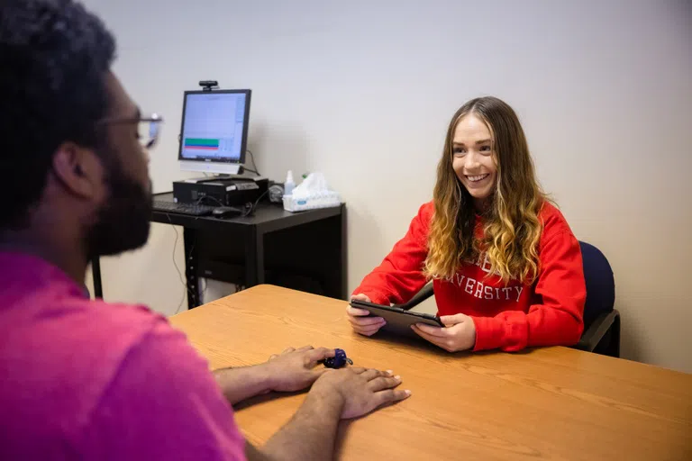 Two people talking over a table conducting psychology tests