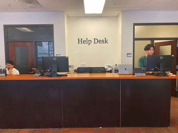 A librarian stands at the Help Desk.