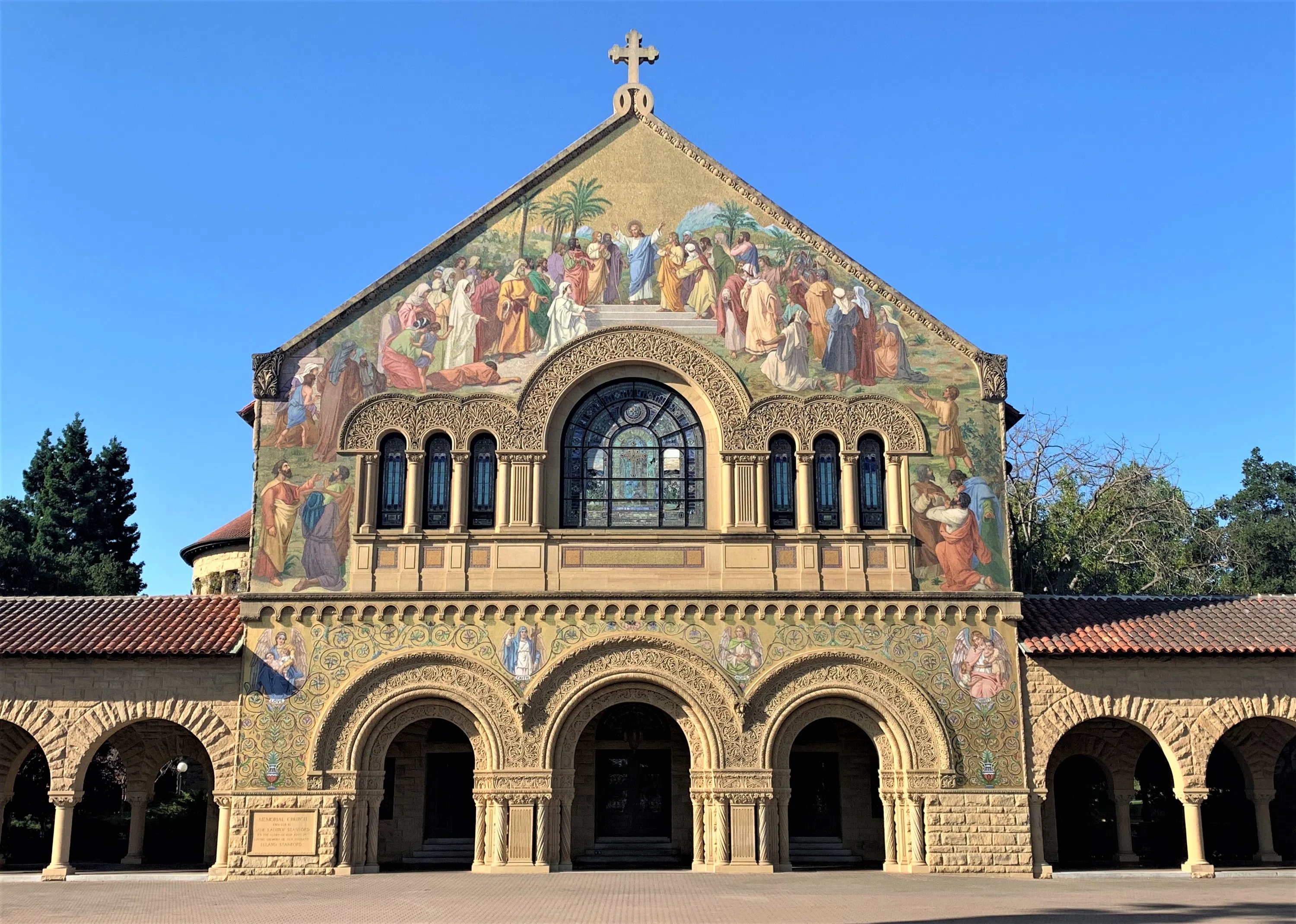 Facade of Memorial Church with arches, large mosaic relief, and intricately carved sandstone.