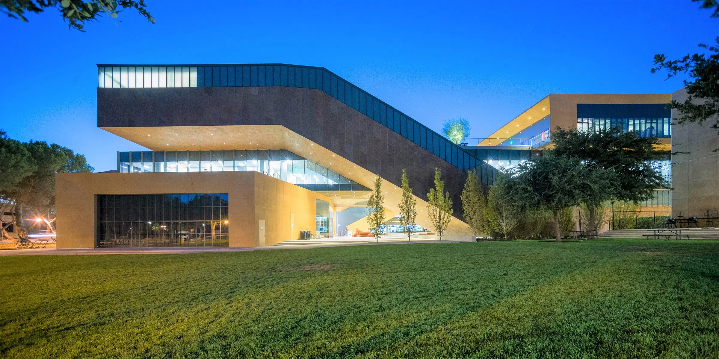 Modern, multiple-story Art building with uniquely angled architecture at dusk 