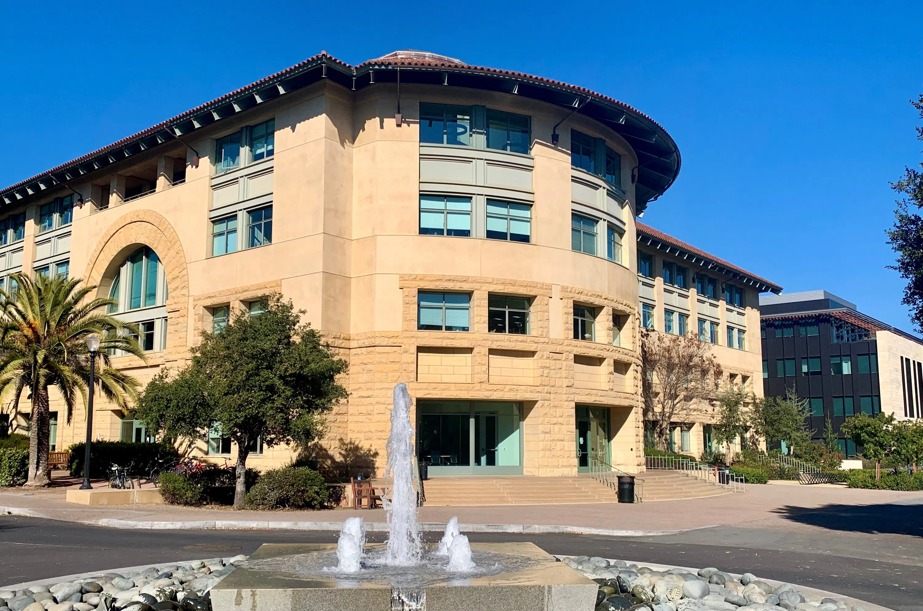 Churning fountain at intersection in center of street with technology buildings