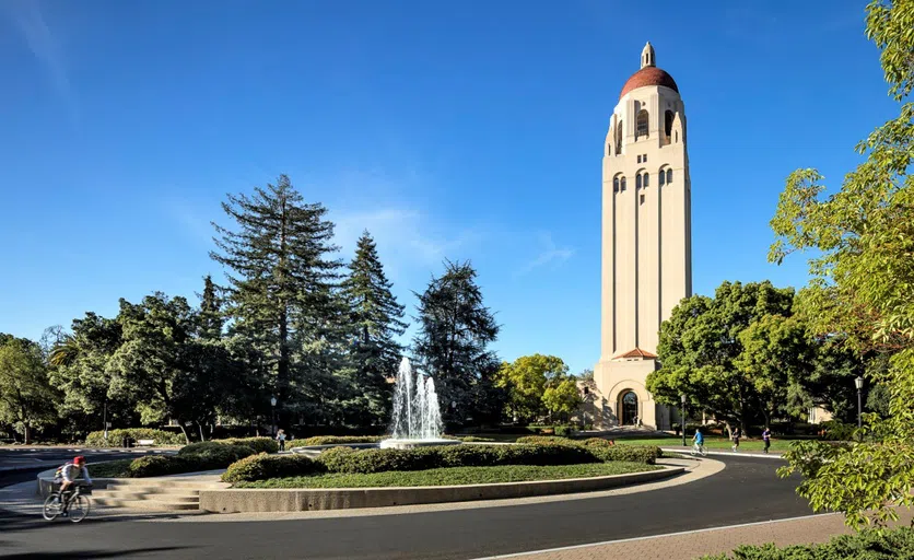 Circular road with fountain at center in front of a 285-foot sandstone tower with rounded dome and observation platform at top..