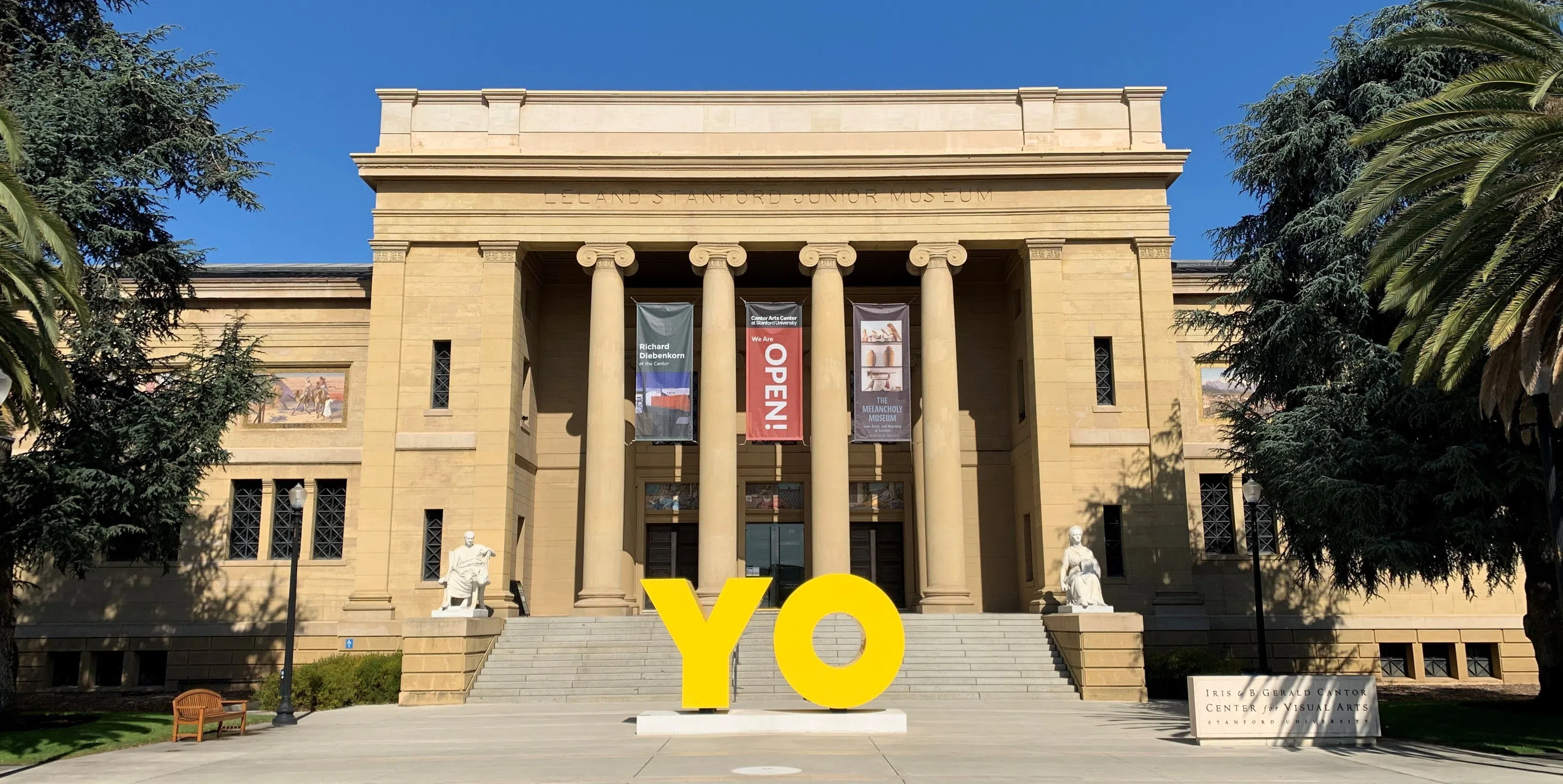 Two images, the first showing the front of the Cantor Center for the Visual Arts building, featuring stone columns and marble statues; the second features the glass-fronted entrance to the Bing Concert Hall