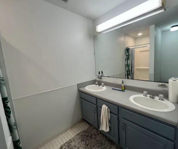 The townhouse bathroom two sinks and stand up shower.