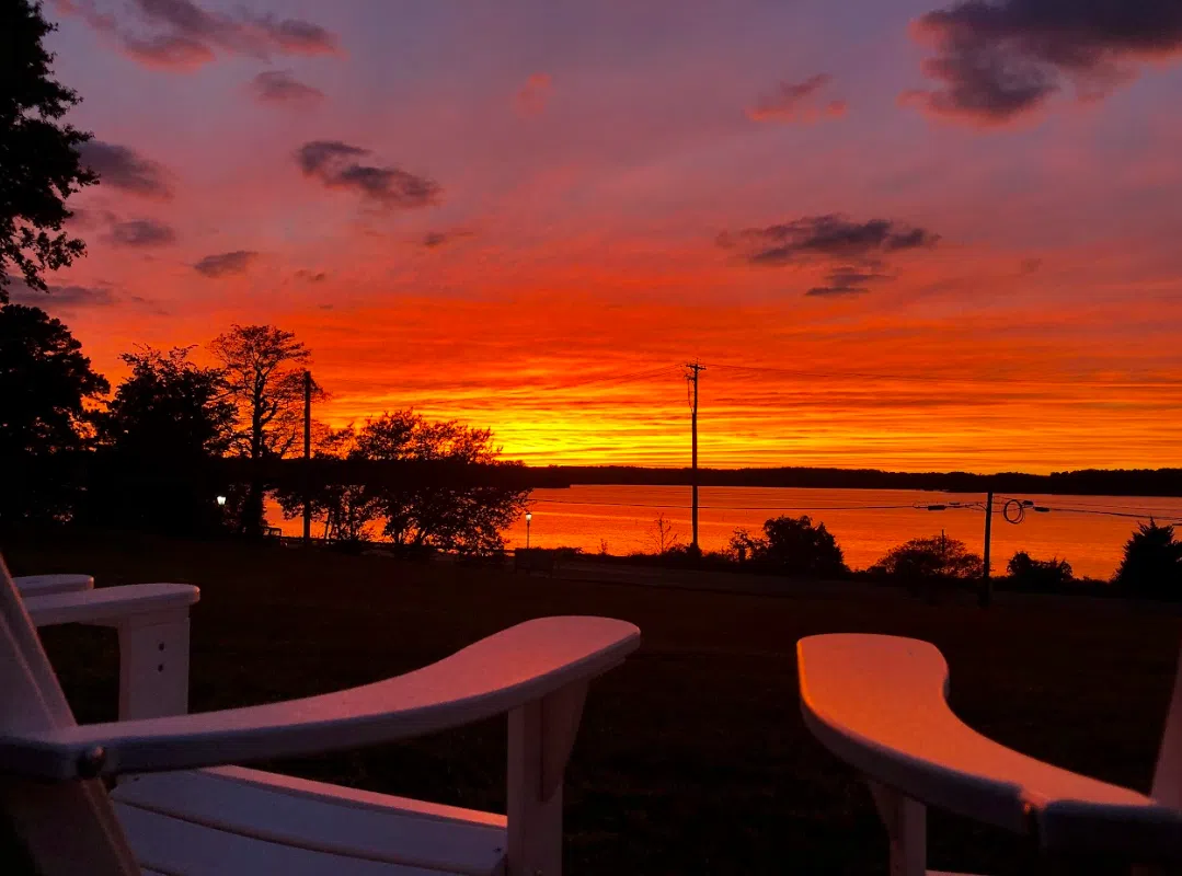 A vibrant sunset with deep orange, red, pinks and purples seen from the front patio at the Admission Welcome Center.