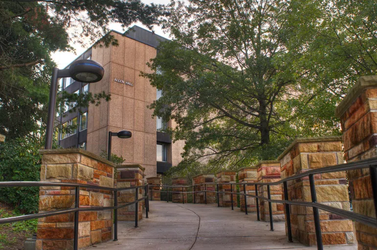 Image shows student walking in front of Allen Hall.