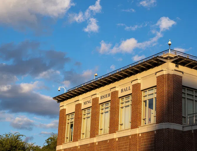 The exterior of Ming Hsieh Hall is set agains a bright, blue sky. 