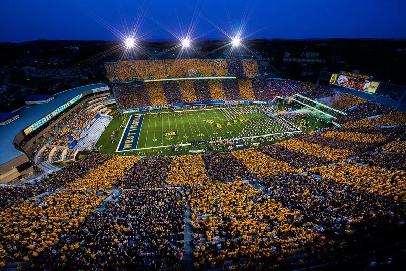 Image shows a nightime game, under the lights at a Stripe the Stadium game with alternating sections of Gold and Blue!