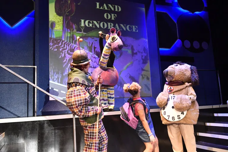 3 WVU acting students stand on stage in costume 